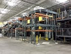 Bushman complete distribution conveyor system, 2 rows of 176' of pallet racking & supports, stairs, structure - Image 1