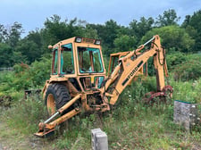 Ford #555-series, backhoe loader - with good tires and attachments.