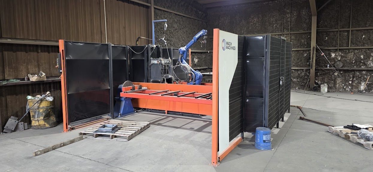 Mach Machines, 2-Position Robotic Welding Cell, headstock/tailstock interpolated axis, manual weld table